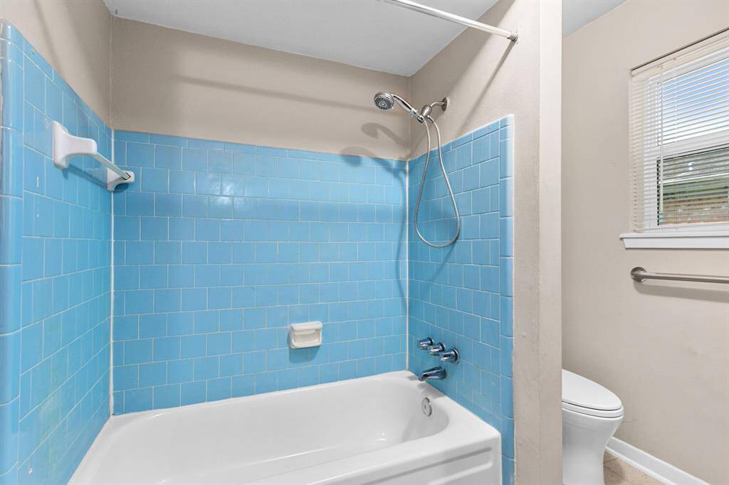 Tub/shower combination with tile surround and new commode.