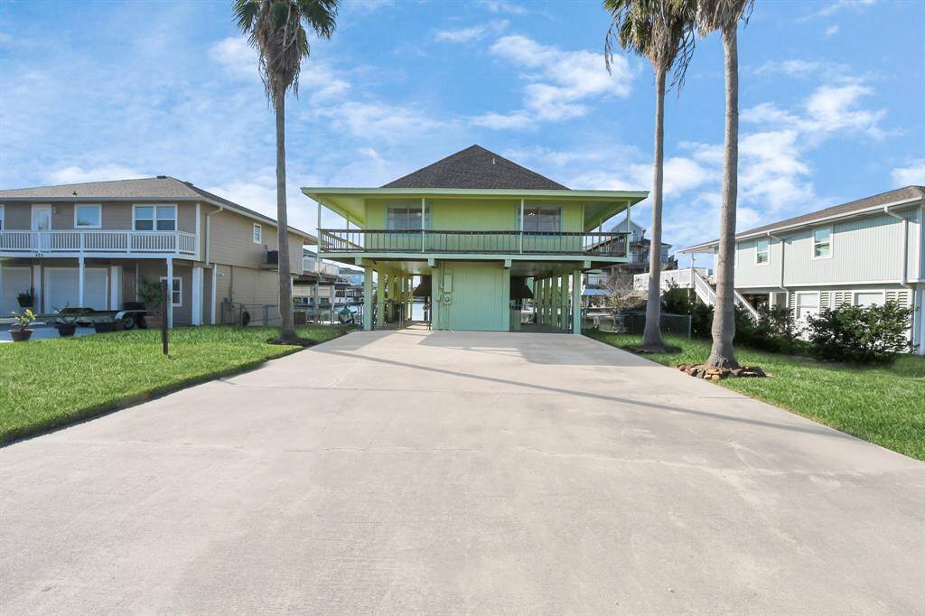 Expansive driveway framed by elegant palm trees.