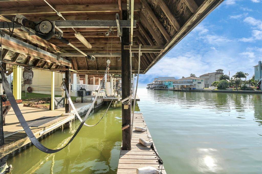 Covered boat dock and lift, offering direct access to a calm canal. Ideal for boating enthusiasts, the area features beautiful homes and a peaceful atmosphere perfect for relaxed living.