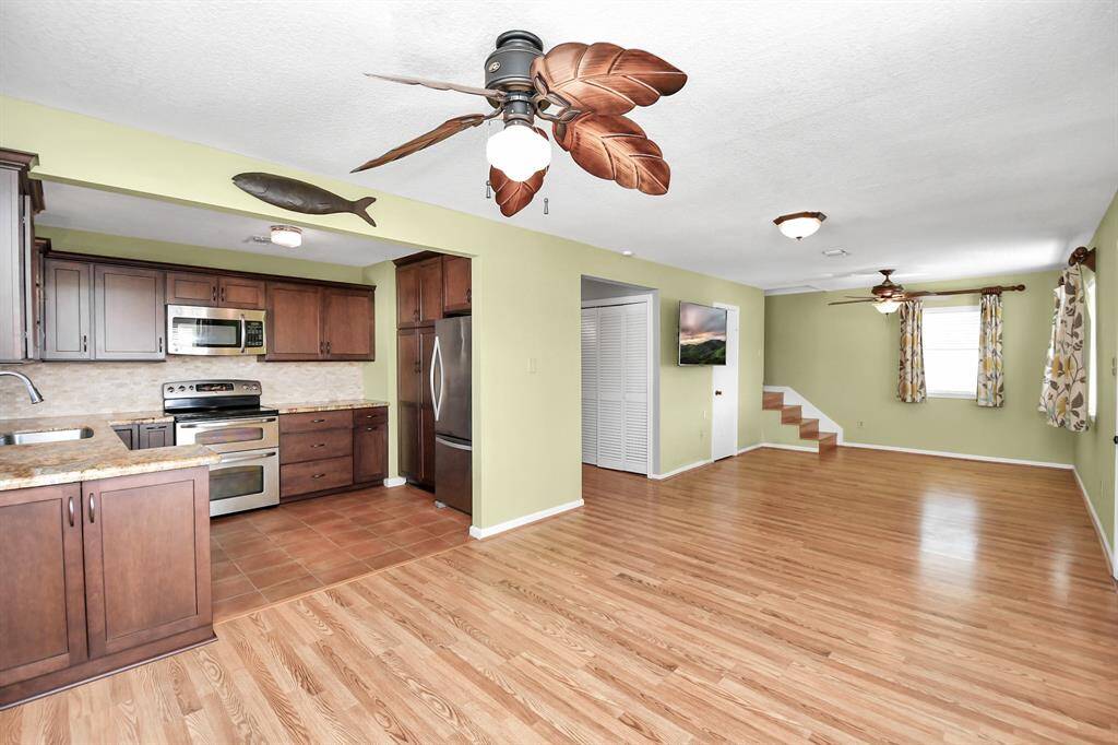 Spacious open-concept dining and living area with abundant natural light and elegant laminate floors.