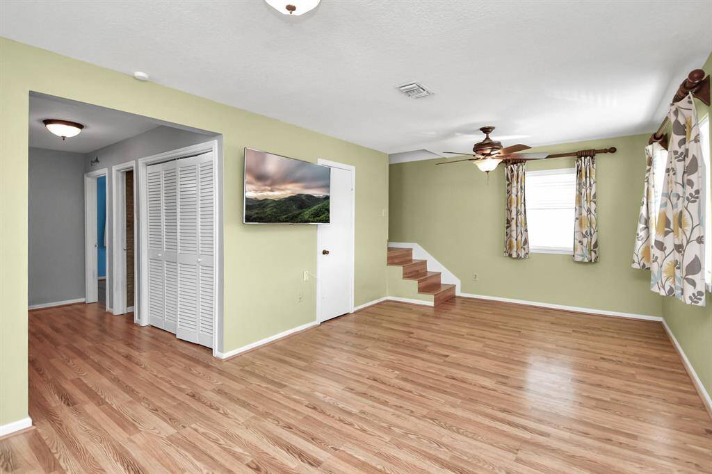 A brief hallway with a utility closet leads to two bedrooms and a full bath.