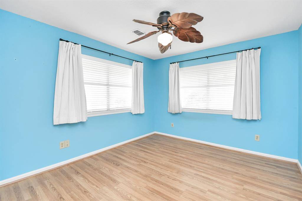 Another view of the bright and airy bedroom 1 with large windows for abundant natural light.
