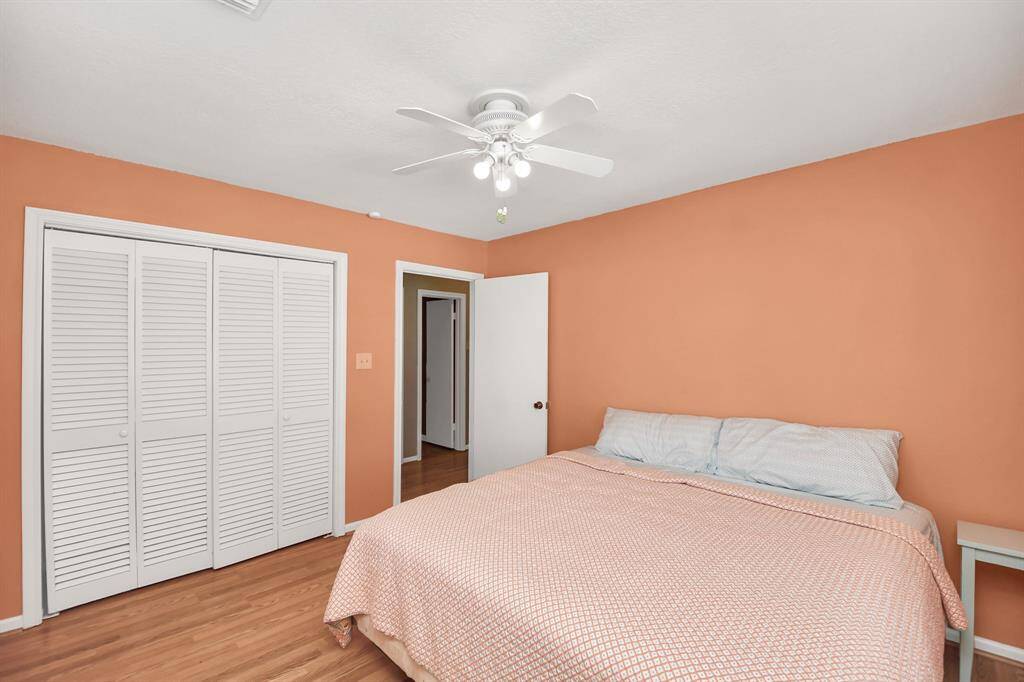 Cozy second bedroom with warm tones, ample closet space, and inviting hardwood floors. Perfect for relaxation or a guest retreat.