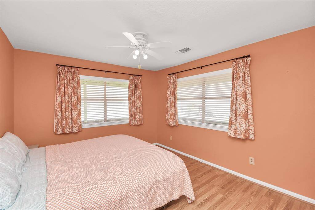 Another view of the cozy second bedroom with natural light and warm decor, perfect for relaxation.