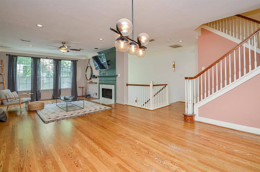This amazing urban oasis can rival any expansive home in suburbia! Isn't this a stunning view from kitchen into this incredible open living space showing the large oak trees out the windows?