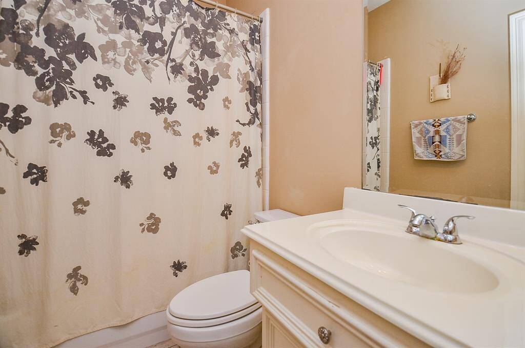 An ensuite bath to the first floor bedroom with combined shower/bathtub, features warm earth tones and plenty of space for your personal rhythms.