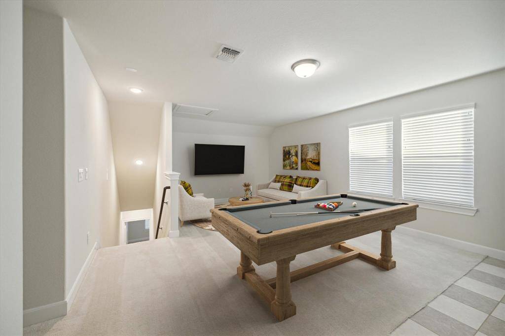 Lofted Game Room staged with pool table, couches and a tv area. An abundance of room to make this room an exercise, games or 2nd living room.