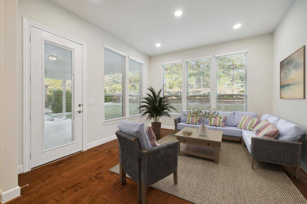 Sunroom staged with furniture. This room walks out to the covered patio and overlooks the backyard. A perfect place to read or enjoy a cup of coffee.