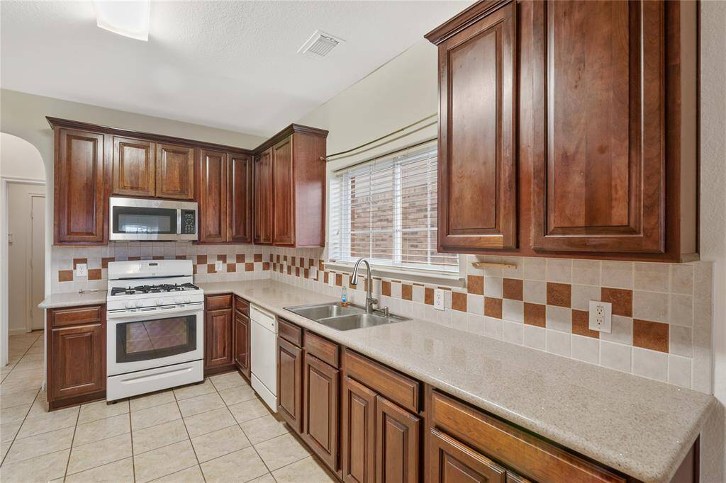Spacious kitchen with grainite countertops and ample storage.