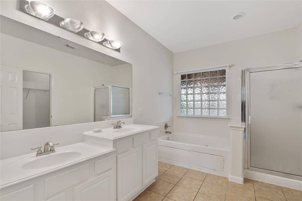 Ensuite master bath, featuring a soothing jetted tub and a separate, glass-enclosed shower.