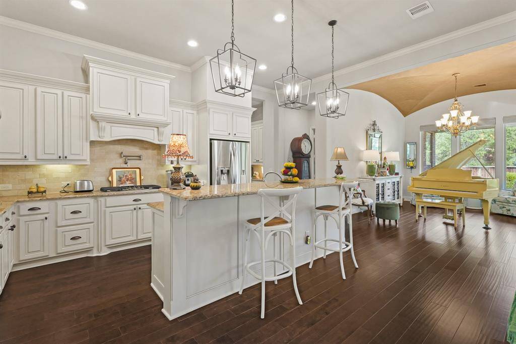 The kitchen has stainless appliances and an new microwave. View to the right is the formal dining room used presently as grand piano room which is surrounded by large windows.