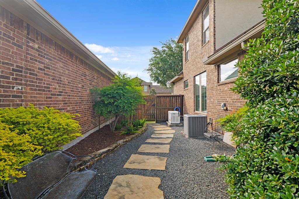 Side of the home has large stone path to the gate past the whole house generator.
