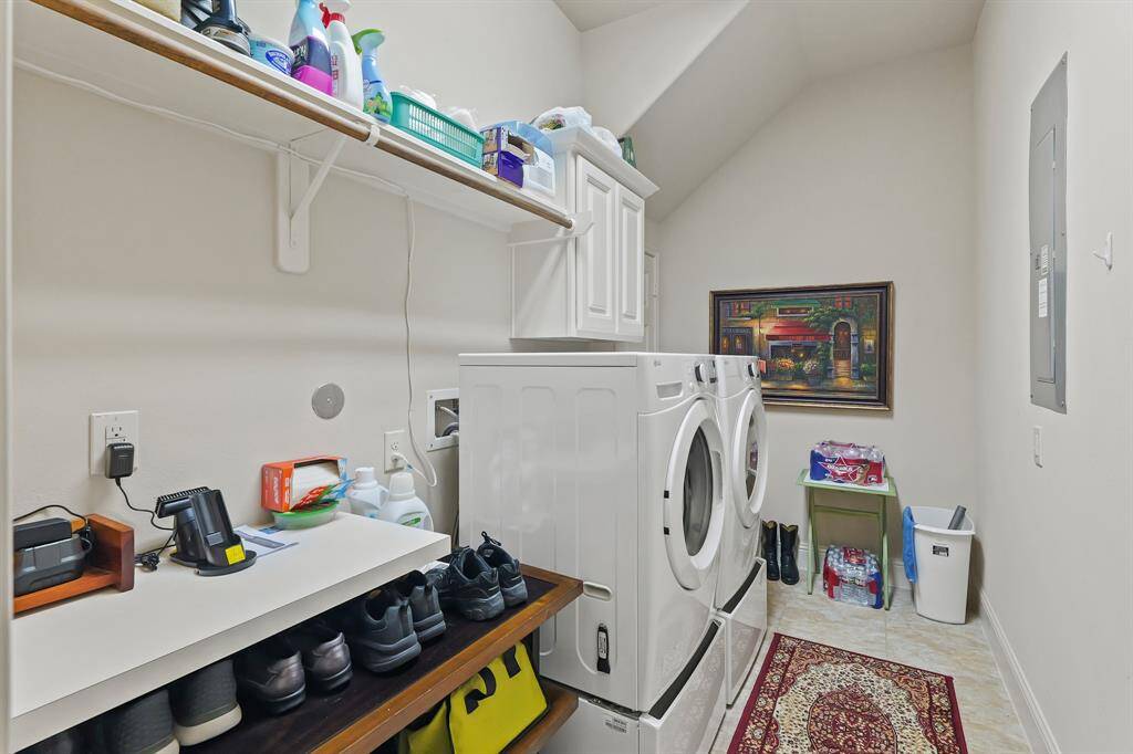 Laundry room is good size to the left of the entry from the garage. Note extra shelving and hanging rods.