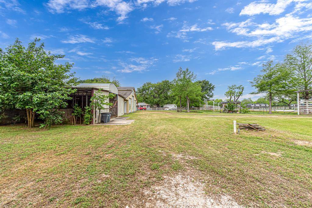 Wide open road frontage with horse stalls and workshop to the left.