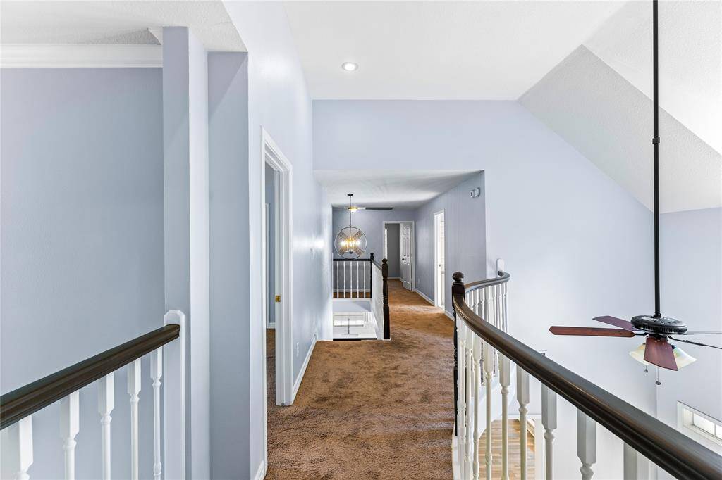 Catwalk upstairs looks down into entry, dining and formal living.  There's a traditional wooden banister, creating a comfortable and open space.