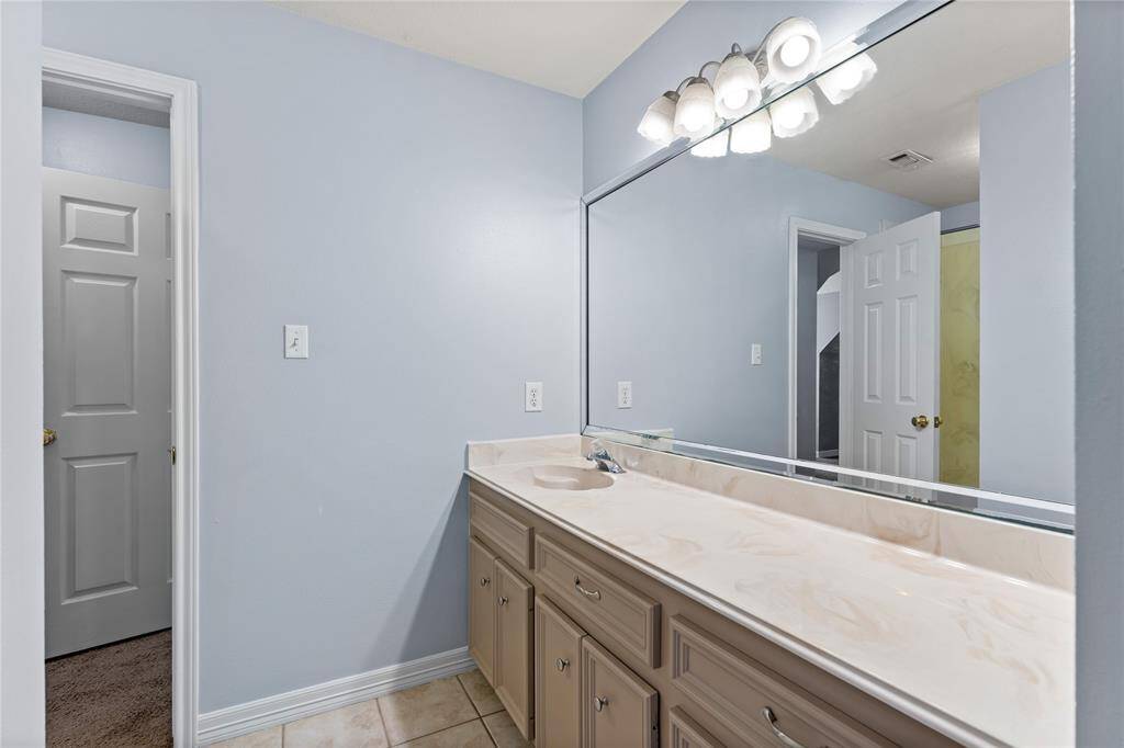 Secondary bath upstairs with a large mirror & ample counter space, and under-sink storage.