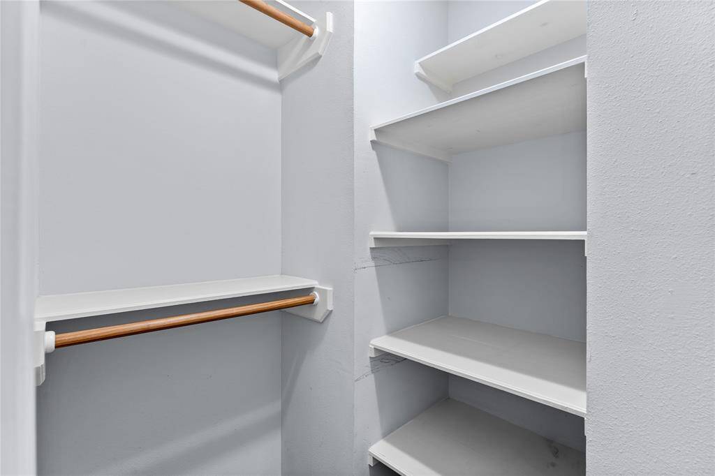 Secondary bedroom closet featuring tons of room for hanging clothes and multiple shelves for organized space optimization.