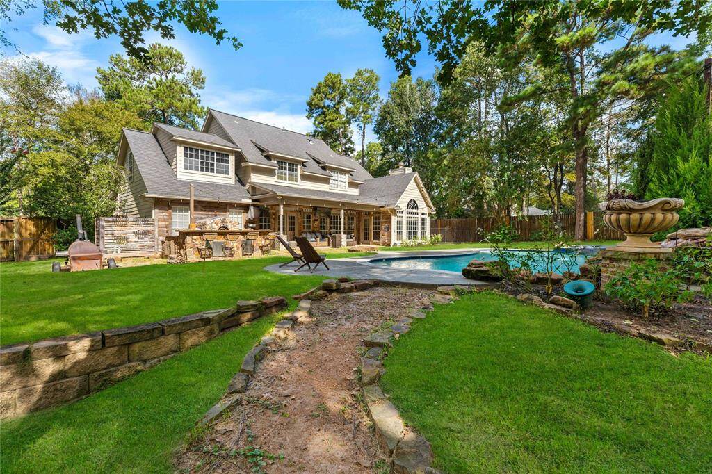 Tranquil backyard oasis with aluxurious swimming poolfeaturing a hot tub andcascading rock waterfall. Apergola provides a shadedrelaxation area amidst lushgreenery for the perfect privateretreat.