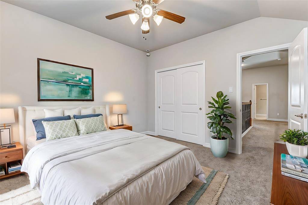 Another bright and spacious bedroom with plush carpet and a ceiling fan. The ample closet space makes it perfect for organizing clothing or personal belongings. This room’s neutral tones offer a blank canvas, ready to be personalized as desired.