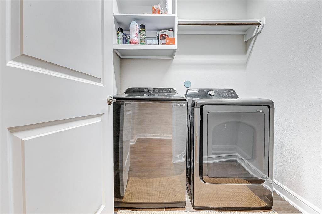 Featuring a high-efficiency washer and dryer, this organized laundry room simplifies household chores. With additional shelving, there's ample space for all your laundry essentials.