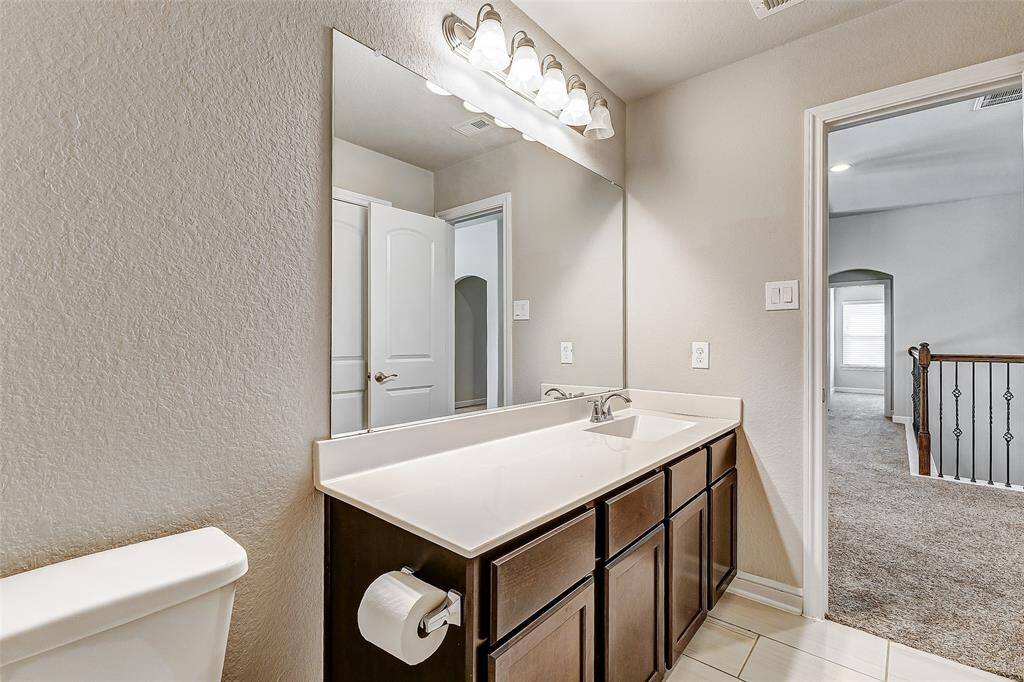 This upstairs bathroom combines practicality with elegance, featuring a wide vanity, mirror, and contemporary lighting. With a seamless design, it provides easy access and serves as a convenient addition for family or guests. Its clean lines and soft color tones make it a soothing and functional space for daily routines.