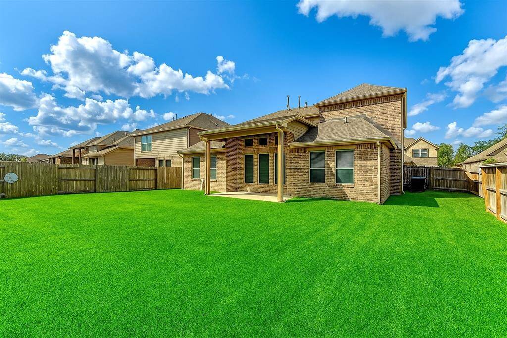 This charming covered patio area provides the perfect space for outdoor dining, entertaining, or simply relaxing in the shade. With ample room for seating and a peaceful view of the backyard, this space seamlessly blends indoor and outdoor living.