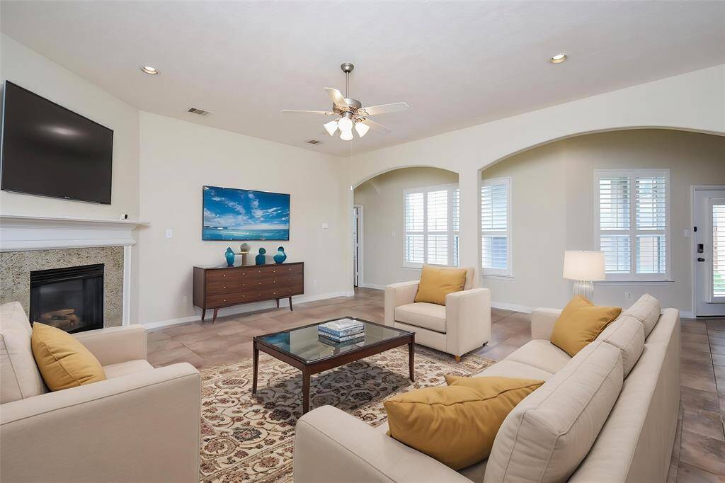 Large Living Room with gas log fireplace, beautiful archways and tile flooring.  (VS)