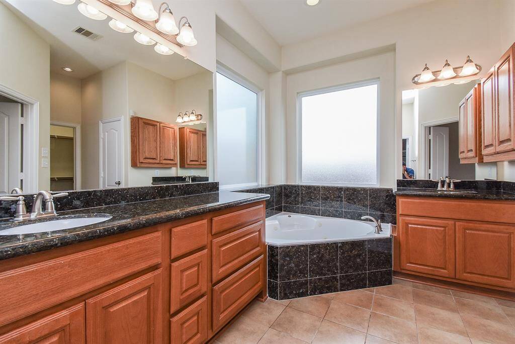 This large Primary Bathroom has separate his & hers sinks with extended counter top, abundant storage and two large frosted windows for natural light.
