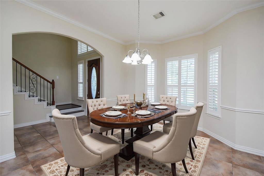 Formal Dining Room with arch doorways, crown molding, chair rail & wall of windows. (VS)