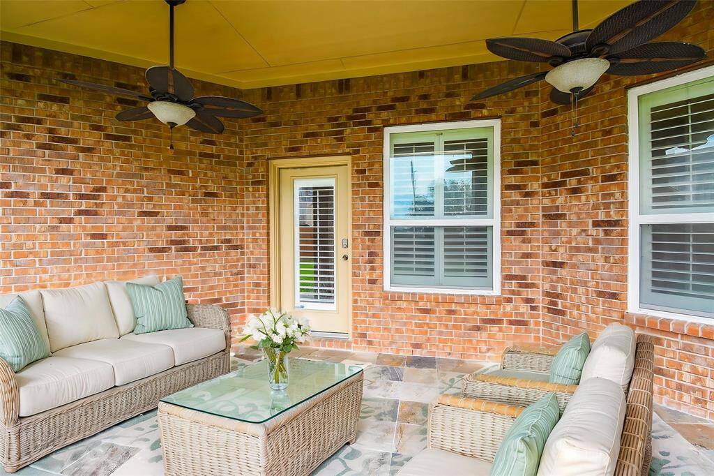 The large covered patio offers plenty of space for outdoor seating & entertaining.  Two ceiling fans help to keep you cool in the summer heat while still enjoying the outdoors.  (VS)