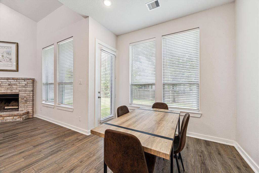 This informal dining area is open to the living area and surrounded by tall windows.