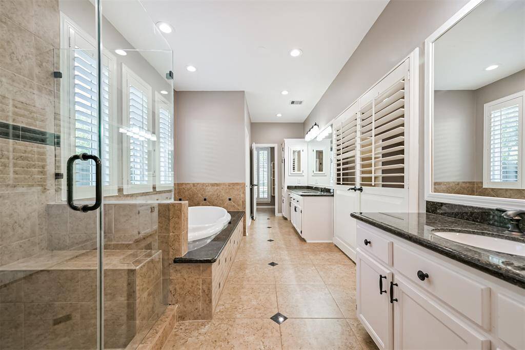 PRIMARY SPA-LIKE BATHROOMFEATURES A SOAKING TUB, DUALVANITIES, AND A SEAMLESSGLASS SHOWER.