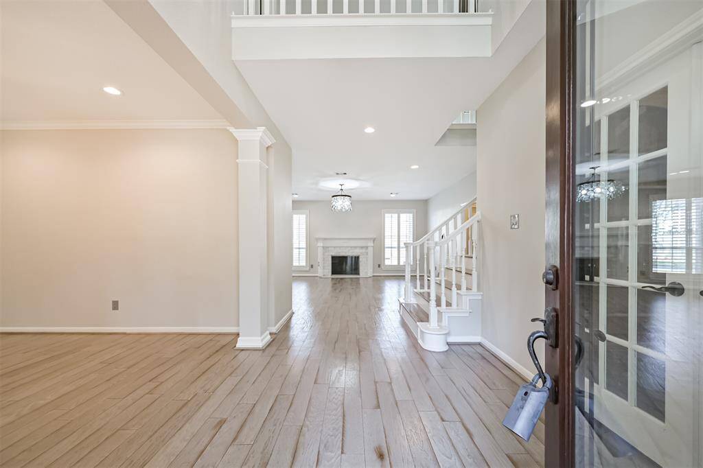 GRAND ENTRYWAY WITHSOARING CEILINGS, WOOD-LIKEFLOORS, AND A VIEW OF THESTUNNING FIREPLACE ANDLIVING ROOM.