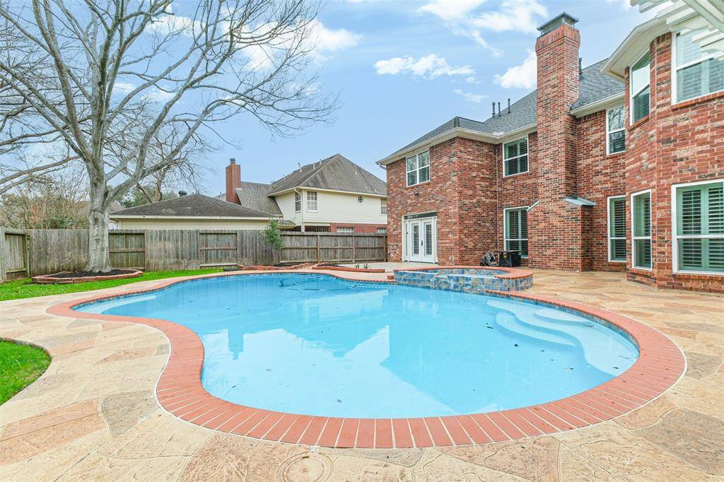 SPACIOUS POOL AND SPASURROUNDED BY EXPANSIVESTONE PATIO FOR ULTIMATEENJOYMENT.