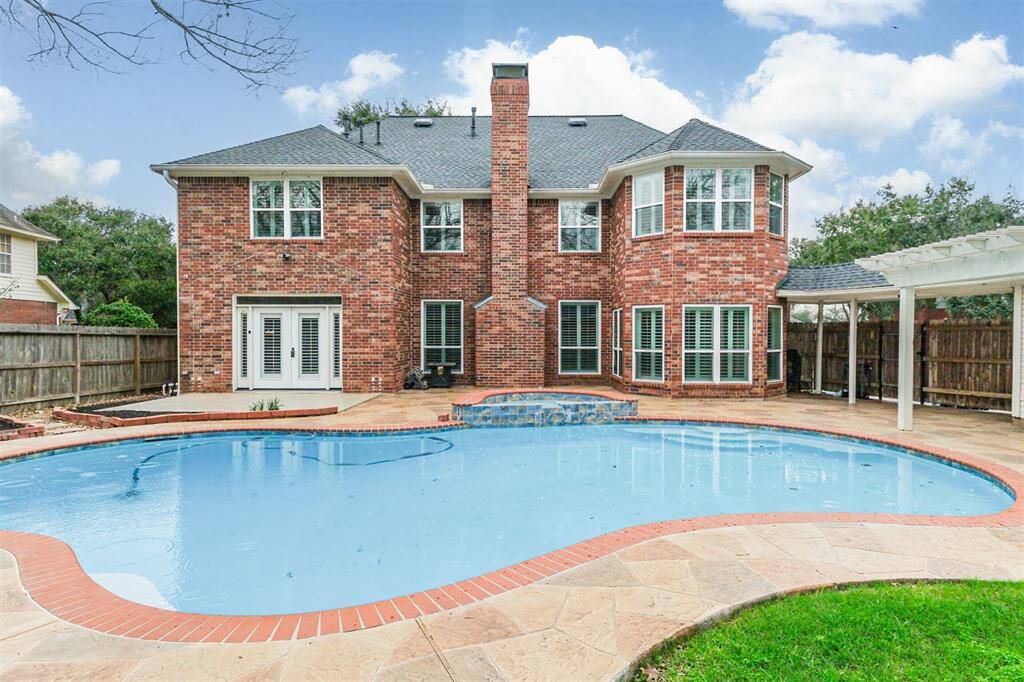 STUNNING BRICK EXTERIORCOMPLEMENTS THE RESORTSTYLE BACKYARD WITHPOOL AND SPA.