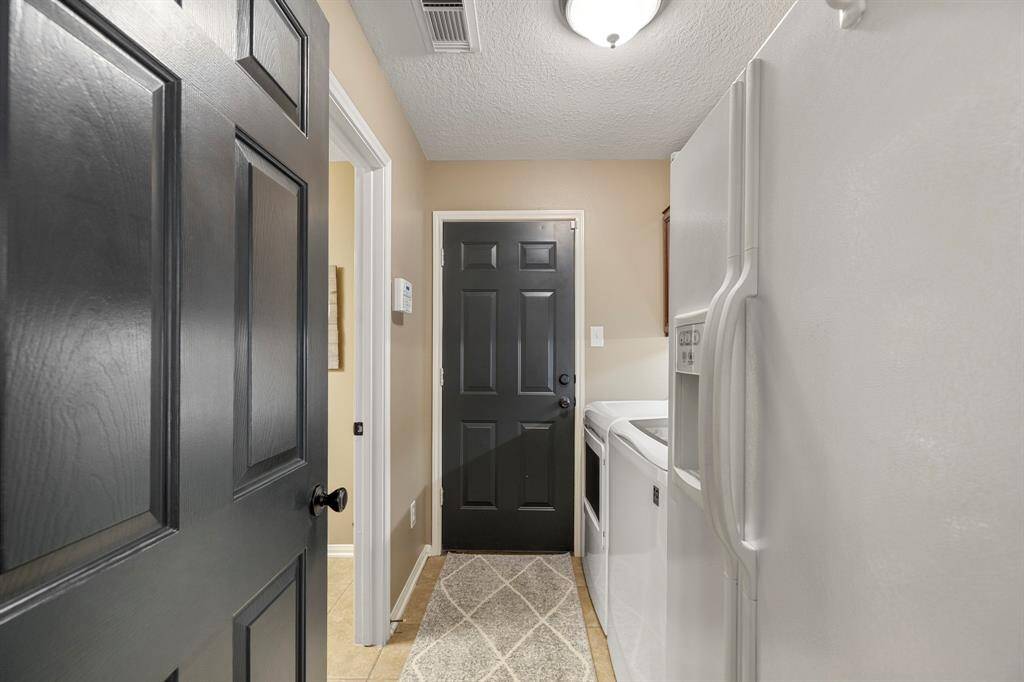 Mud room and laundry area with access to garage. Washer, Dryer & Refrigerator can stay.