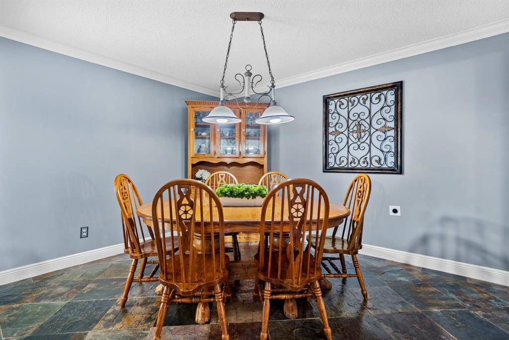 This dining room features custom paint, tile floors, and crown molding.