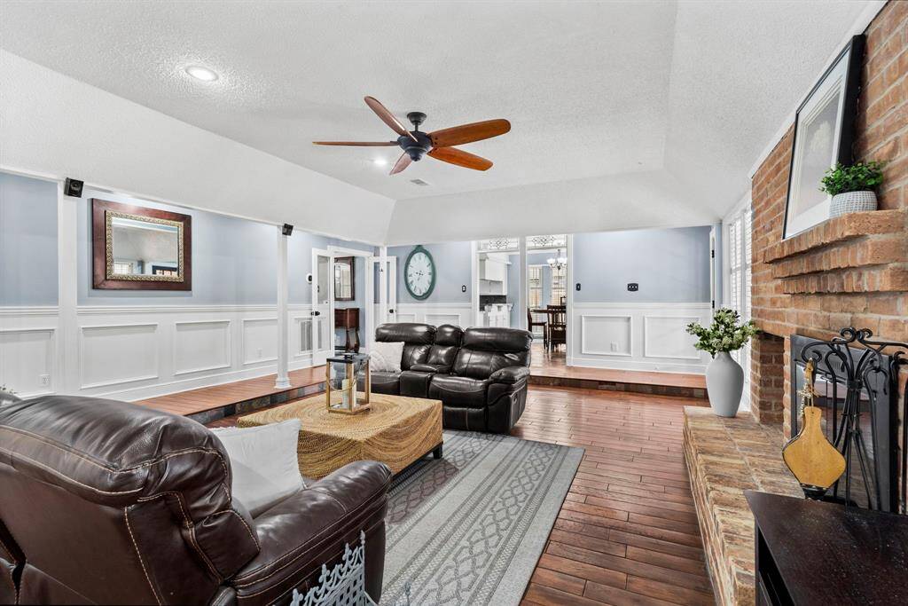 Living room features beautiful flooring, aceiling fan, high ceilings, and recessed lighting.