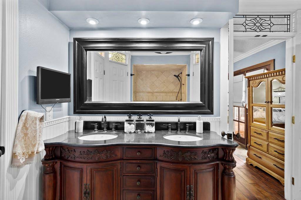 The primary bathroom has dual sinks and wood cabinets.