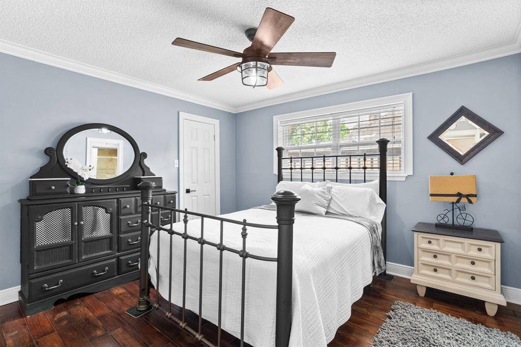 Secondary bedroom features awindow, custom paint, crown molding, and ceiling fan.