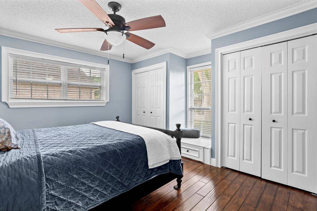 Third bedroom features largewindows, custom paint, crown molding, and a ceiling fan.