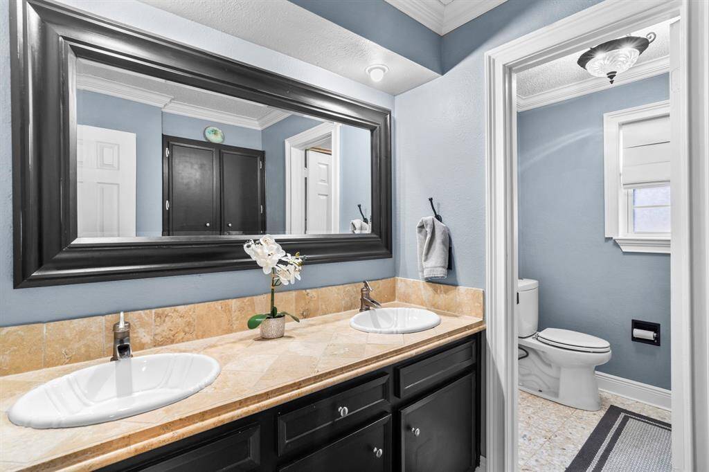 Secondary bathroom features a long vanitywith dual sinks and plenty of counter space.