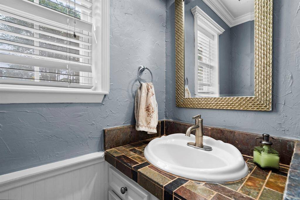 The utility room bathroom has a slate vanity and a small window.