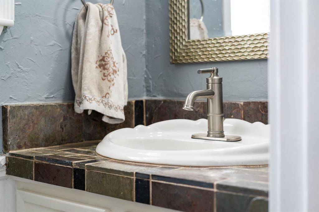 The utility room bathroom has a slate vanity and a small window.