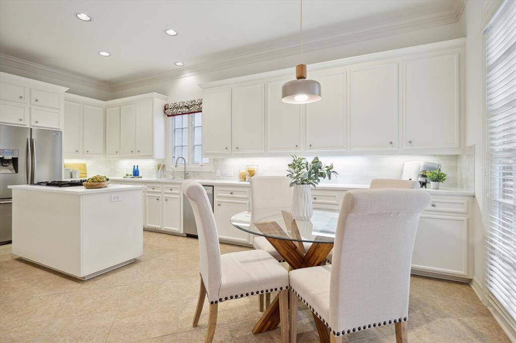 KITCHEN.  Updated in 2025 with quartz countertops, new tile backsplash and breakfast area light fixture, the kitchen forms the heart of the home and is a perfect spot for family and friends to gather.