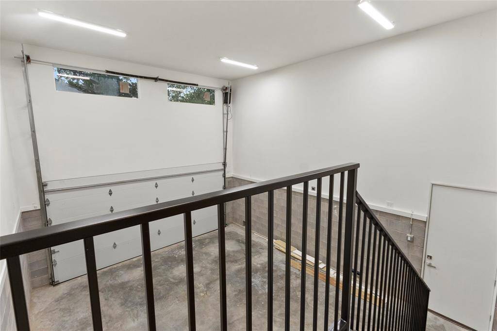 High ceiling garage with potential for additional storage or lift for cars. Additional walk in storage beneath the stairs as part of foundation area