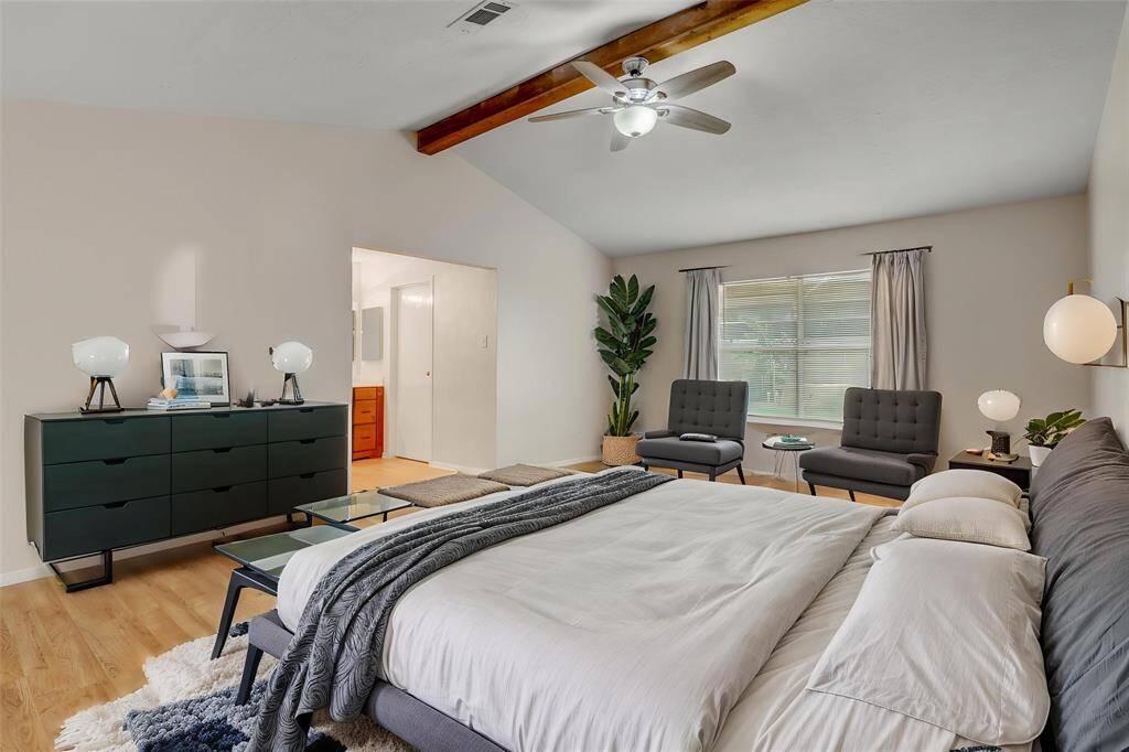 The primary suite is incredibly open and spacious, with vaulted ceilings, accent beam, and room for a sitting area.