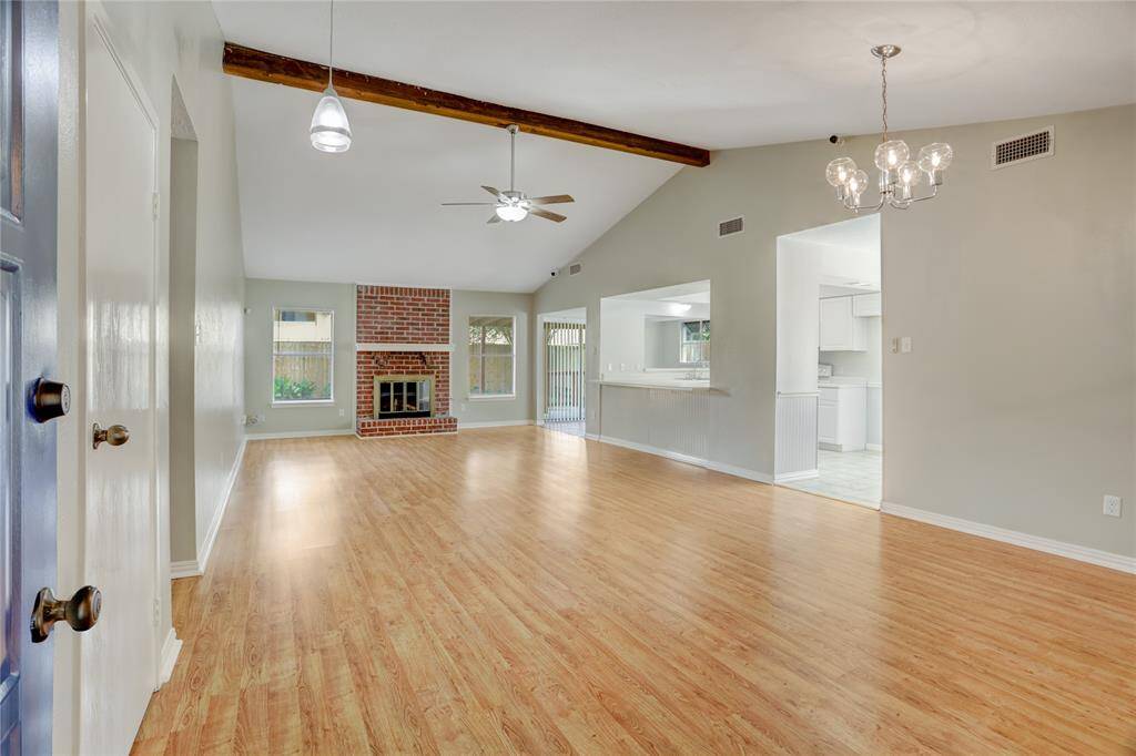 As you enter the home, you are greeted with an expansive, light-filled living room with a lovely wooden beam.