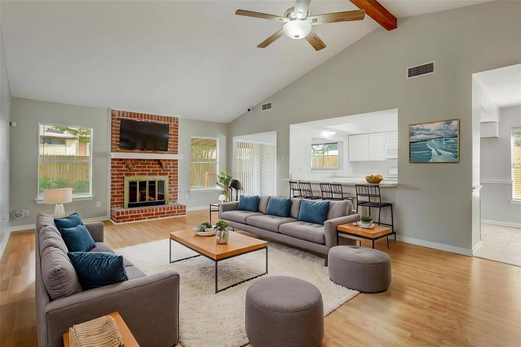 The virtual staging shows off the size of the living room, with a beautiful fireplace and room for barstools at the kitchen bar.