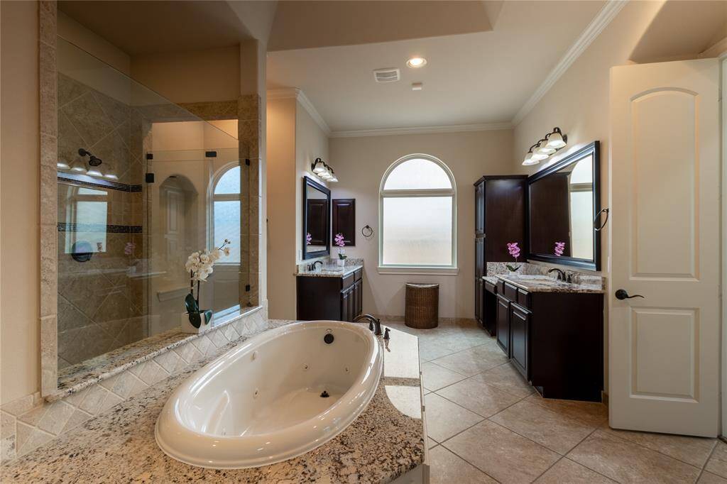 Primary bathroom with large walk through shower, dual vanities and jetted tub.